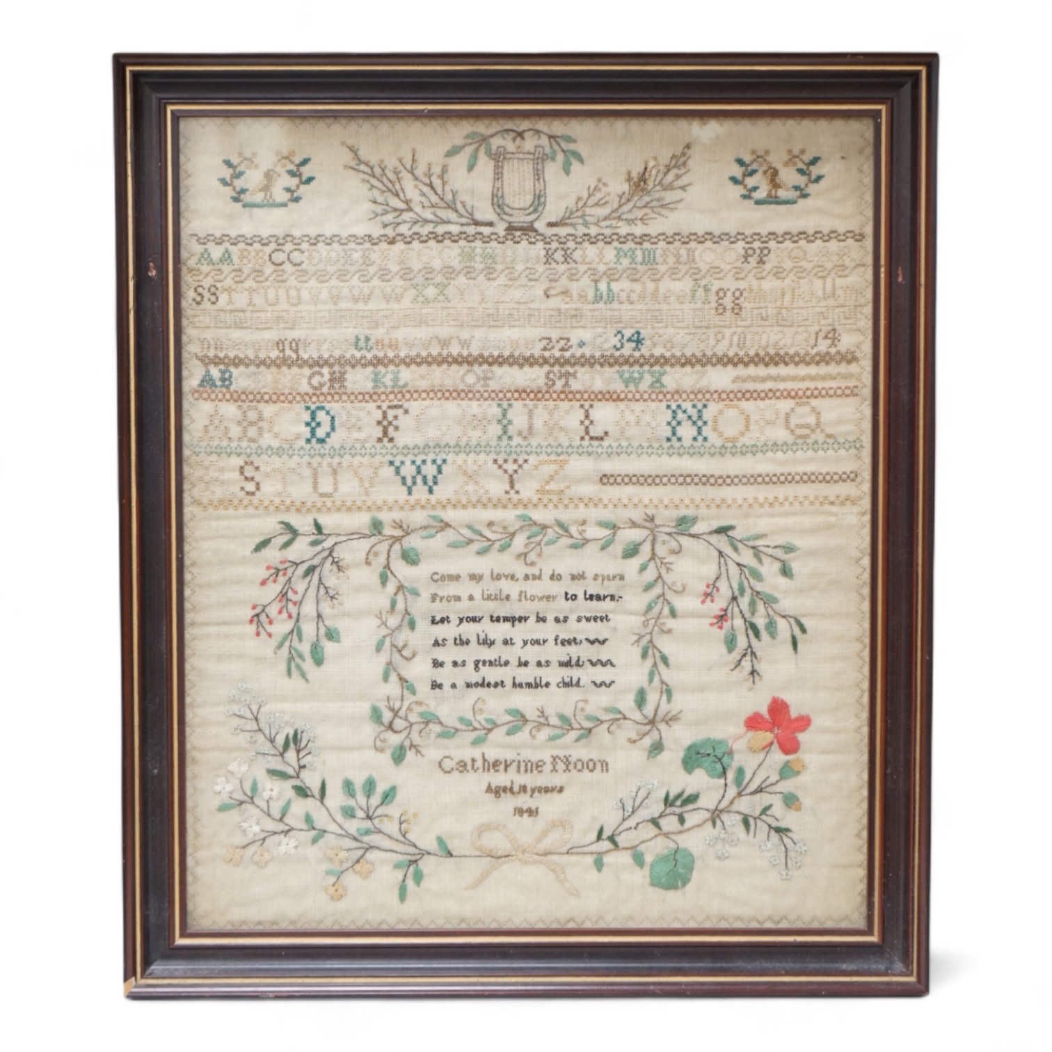 A framed 19th century alphabet sampler by Catherine Noon, dated 1841. Embroidered at the top with a harp and two birds and rows of alphabet and numbers, a central cartouche of verse below and her name and date above a fl